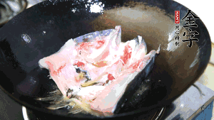 魚(yú)頭處理干凈后對(duì)半切開(kāi)，入加熱油的鍋中略煎。