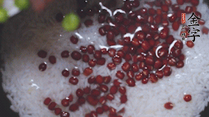 將炒好的食材和大米、紅豆一起放進(jìn)電飯鍋煮。
