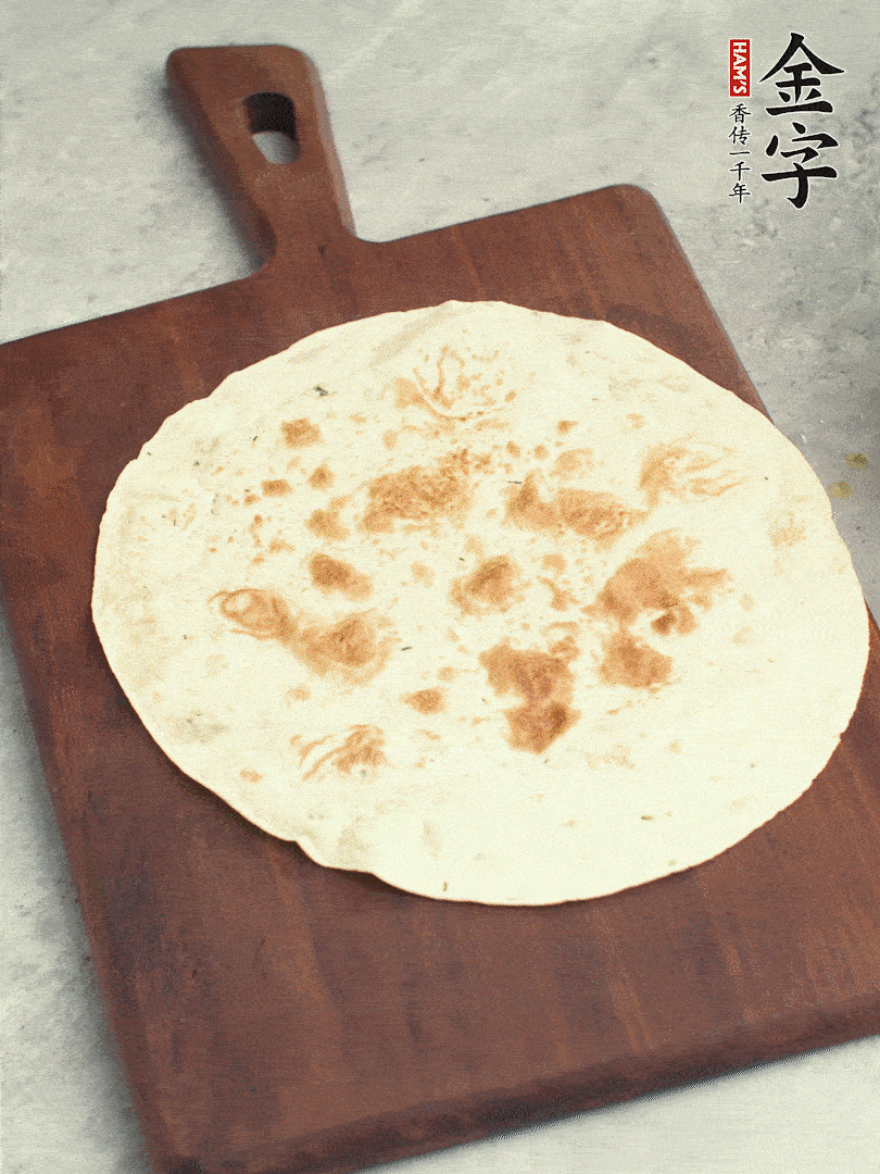 食材依次鋪在卷餅皮上，卷起來。