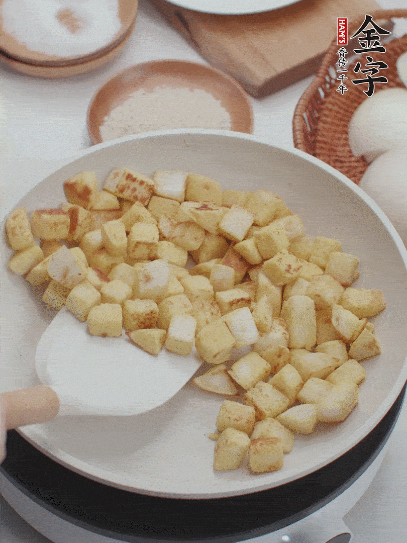 起鍋熱油，倒入饅頭丁，小火煎至蛋液凝固定型再翻面，饅頭丁部煎至金黃時盛起待用。