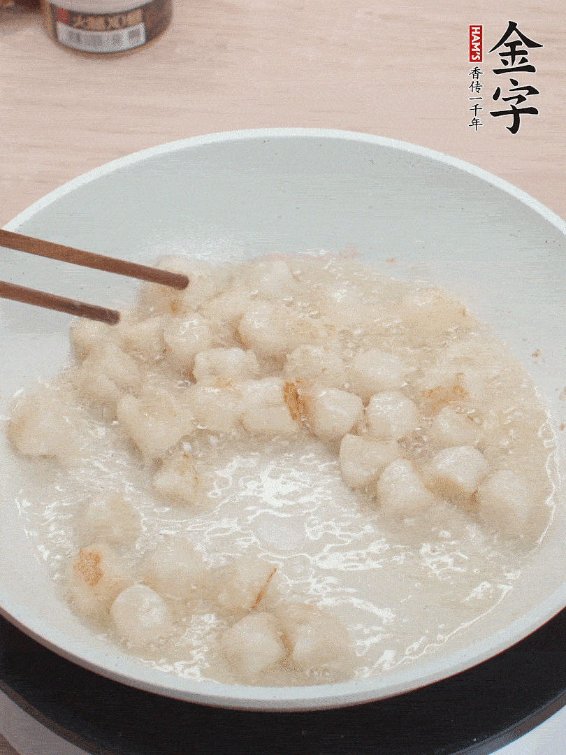 油溫4成熱，鮮貝蘸干淀粉下鍋煎，一面微黃后翻面。