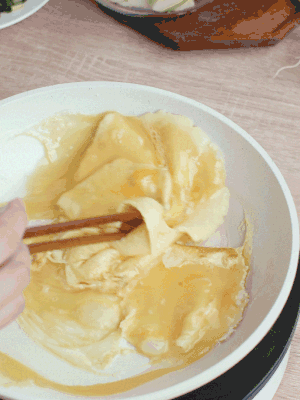 油6成熱時(shí)，下雞蛋液，邊緣凝固時(shí)翻拌成塊狀。