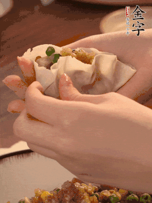 取一大勺餡料放進餃子皮里，用大拇指按住頂部餡料，再用虎口掐出形狀。