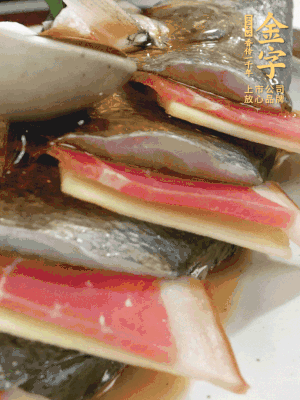 魚肚中塞蔥結(jié)、火腿片，魚身上碼放姜片、火腿片，倒入混合的料汁。