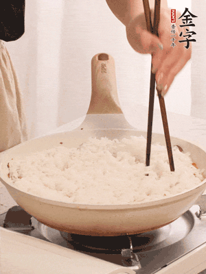把瀝干水分的米飯均勻鋪在上面，筷子戳幾個洞，以便透氣，轉(zhuǎn)小火蓋上蓋子燜至水分收干，大概10分鐘。