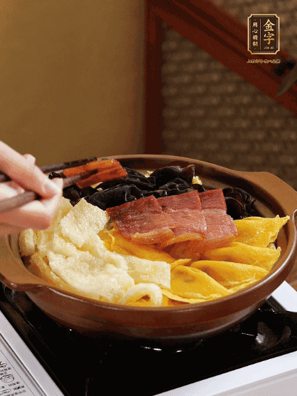 砂鍋底部鋪上娃娃菜，依次擺上肉皮、蛋餃、黑木耳、火腿